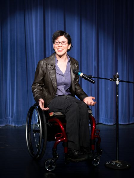 woman in a wheelchair at a microphone